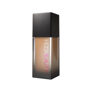 Huda Beauty FauxFilter Foundation rectangular translucent to black gradient bottle of foundation with black cap on white...